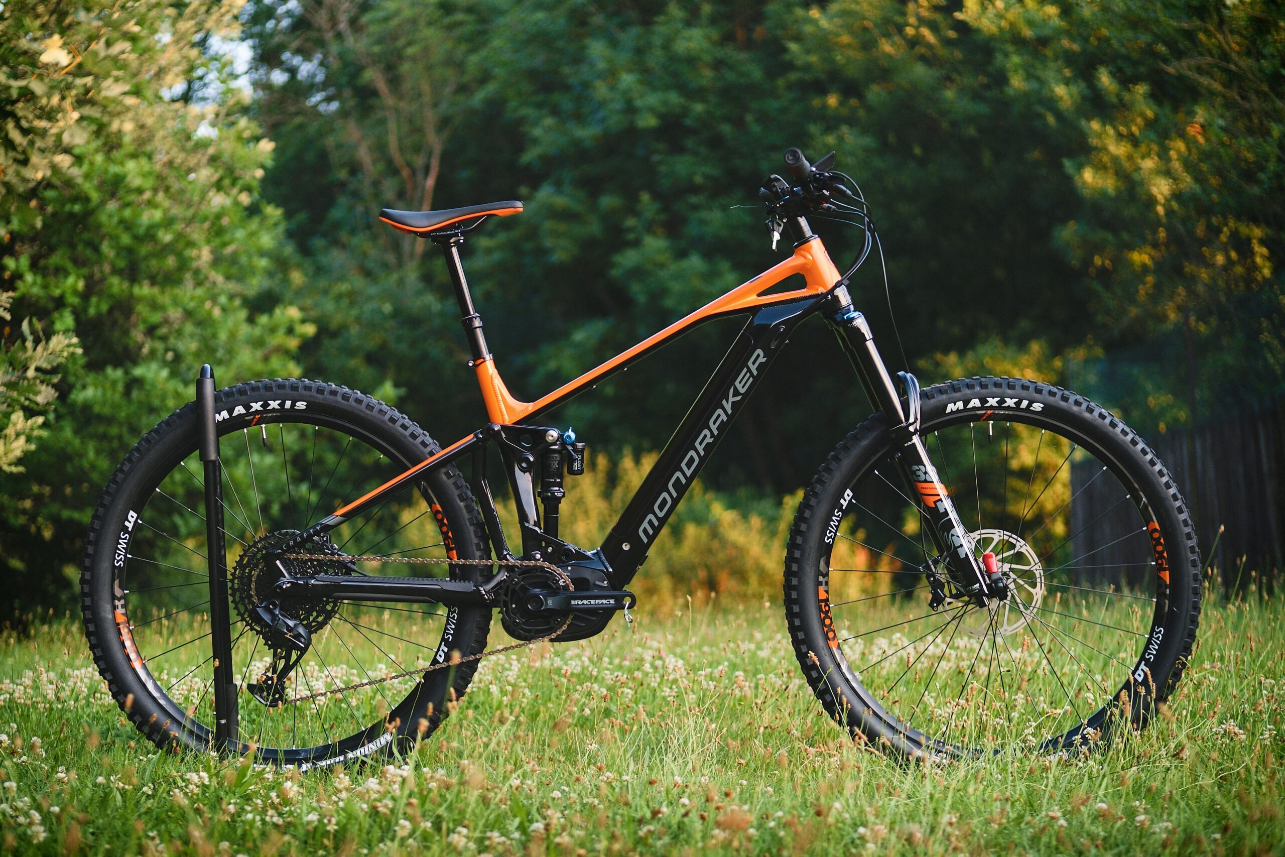 High-quality image of a mountain bike parked in a grassy area surrounded by trees.